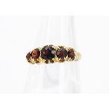 An 18ct gold five stone garnet ring, circular mixed cuts, claw setting all in yellow gold,