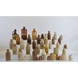 Fourteen stoneware ginger beer bottles, Lewis & Nevett, Thomas & Clarke, a larger example with a