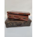 Two vintage leather suitcases, one with base metal corners, plastic handle, the other with leather