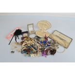 A collection of beads, including a cased set of simulated pearls, another in a shell case, small