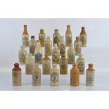 Twenty Two stoneware ginger beer bottles, from around the World including Columbo ceylon, William