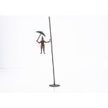 A Pre-War German Clown Gravity Toy, lithographed steel clown holding umbrella, attached to pole