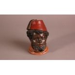 A late 19th century German ceramic figural tobacco jar, 14cm, modelled as young man in a fez