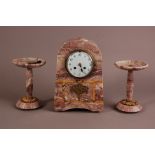 An Art Deco period French marble clock garniture, pink mottled stone clock with eight day