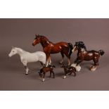 A collection of four Beswick pottery horses and one other pottery horse, the white and grey