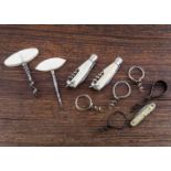 A selection of small one finger pulls miniature corkscrews, small pocket pen knives with corkscrews