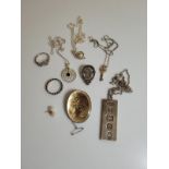A collection of silver and white metal jewellery, including a silver ingot pendant and chain,