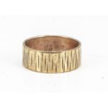 A 9ct gold textured wedding band, ring size T, 8.1mm, 5.1g