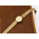 A c1980 Omega 9ct gold lady's wristwatch, 12mm wide oval case on integrated 9ct gold mesh link