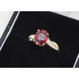 An 18ct gold ruby and diamond dress ring, the oval mixed cut in four claw setting with diamond set