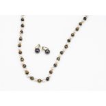 A string of tiger's eye and cultured pearl beads, united by 18ct gold clasp, the knotted pearls
