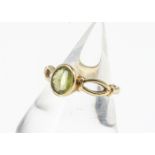 An 18ct gold peridot dress ring, with oval open shoulders, marked 18 to inner shank, ring size Q,