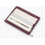 A collection of coloured garnets set in a channel in a leatherette case