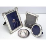 Two modern silver photograph frames, together with a silver plated rectangular example and a