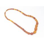 A graduated string of oval amber toffee coloured beads, 33g, 27cm together