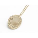 A 9ct gold oval floral engraved locket and chain, total length 26.5cm, 8.1g