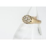 An 18ct gold diamond cluster dress ring, the seven old cut stones in claw setting marked