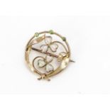 An Edwardian Art Nouveau 15ct opal and demantoid garnet circular brooch, the two clover leaves set