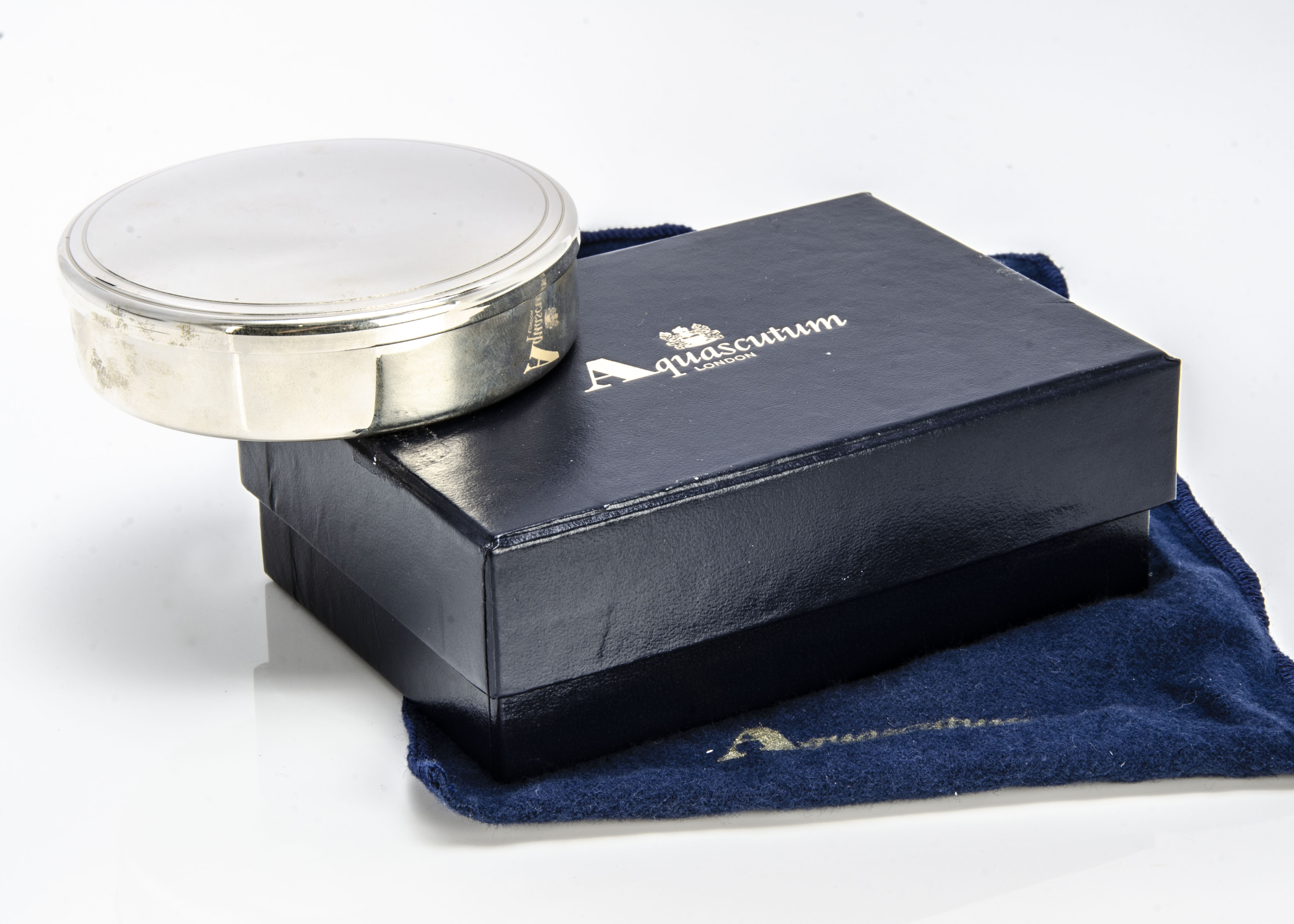 A modern sterling silver box from Aquascutum, 8.5cm diameter, 5 ozt, with blue velvet lining, with