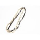 A contemporary black and cream pearl uniform string of knotted cultured pearls, with contemporary