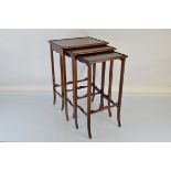 A mahogany nest of three tables, having raised border, four shaped tapering legs and shaped
