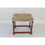 An oak framed Parker Knoll stool, with stamps to inner frame, baluster supports, block feet,