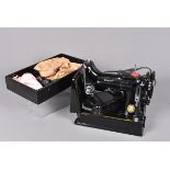 An electric Singer Sewing Machine in carry case, in traditional black with applied gilt