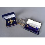 A small collection of aviation related badges and cufflinks, comprising white metal bi-plane
