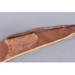 A rolled leather sheep skin padded gun slip, with decorative floral pressed leather decoration to