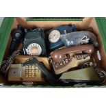 A collection of five vintage telephones, including rotary and push button examples, in various