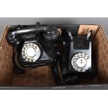 Two vintage black plastic rotary telephones, both with pull out note slides to the bottom, plus