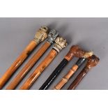 A collection of six animal-headed walking sticks, comprising four with dogs heads, in pewter, resin,