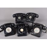 A group of five black vintage rotary telephones, complete with hand sets, a couple of different