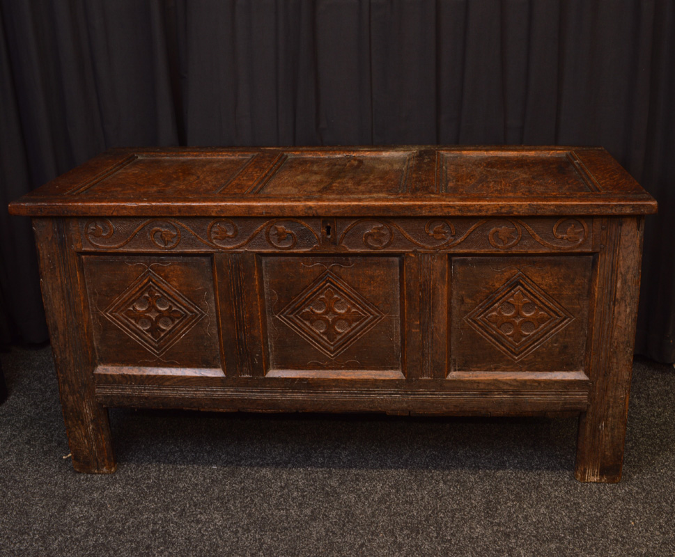 A rectangular carved oak blanket box, having inner candle box, metal ring hinges, three panel lift