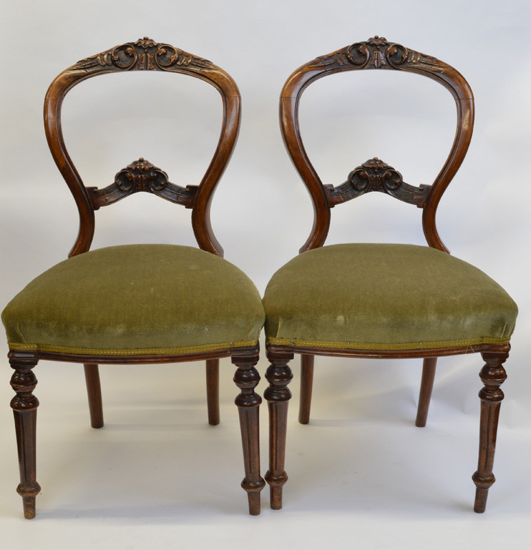 A set of six Victorian walnut framed balloon back chairs, having carved and shaped top rail and back