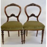 A set of six Victorian walnut framed balloon back chairs, having carved and shaped top rail and back