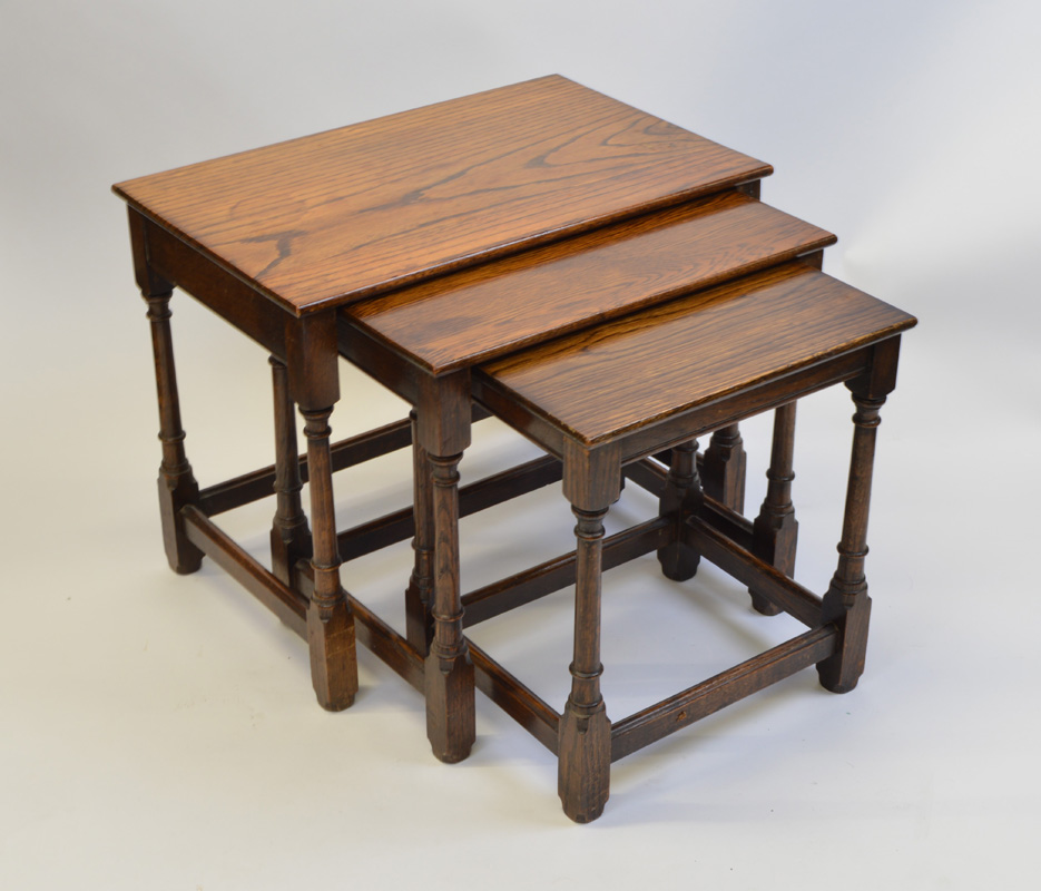 An oak nest of three tables, having rectangular tops om turned legs with block feet, largest 32.