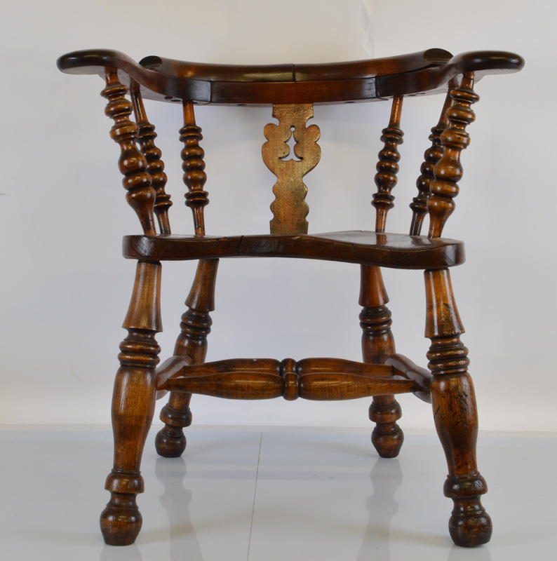 An oak smokers bow armchair, having yew moulded seat, spindle and bobbin back supports, turned