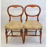 A pair of mahogany framed balloon back bedroom chairs, having shaped floral upholstered stuff over