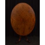 A Victorian burr walnut oval loo table, having carved scroll border on vase support, four carved