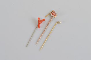 Three vintage stick pins, including one with coral terminal, and two gilt metal examples, one with