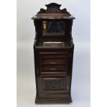 A mahogany music cabinet, having shelf over raised mirror back, five shelves under with glazed