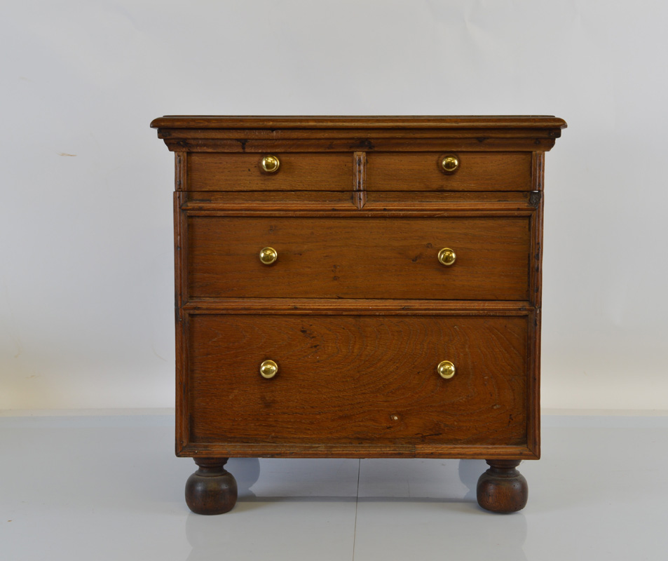 An oak commode chest, having two over two drawers with brass handles on squat feet, 50cm x 41cm x