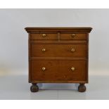 An oak commode chest, having two over two drawers with brass handles on squat feet, 50cm x 41cm x