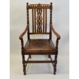 An oak framed throne armchair, having leather pad seat, moulded arm supports, carved vase back