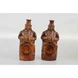 Two treacle glazed figural flasks, Toby atop barrel, 24.5cm and 25cm high (2)