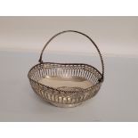 A George V silver swing handled pierced circular basket, of circular shape with shaped outline,