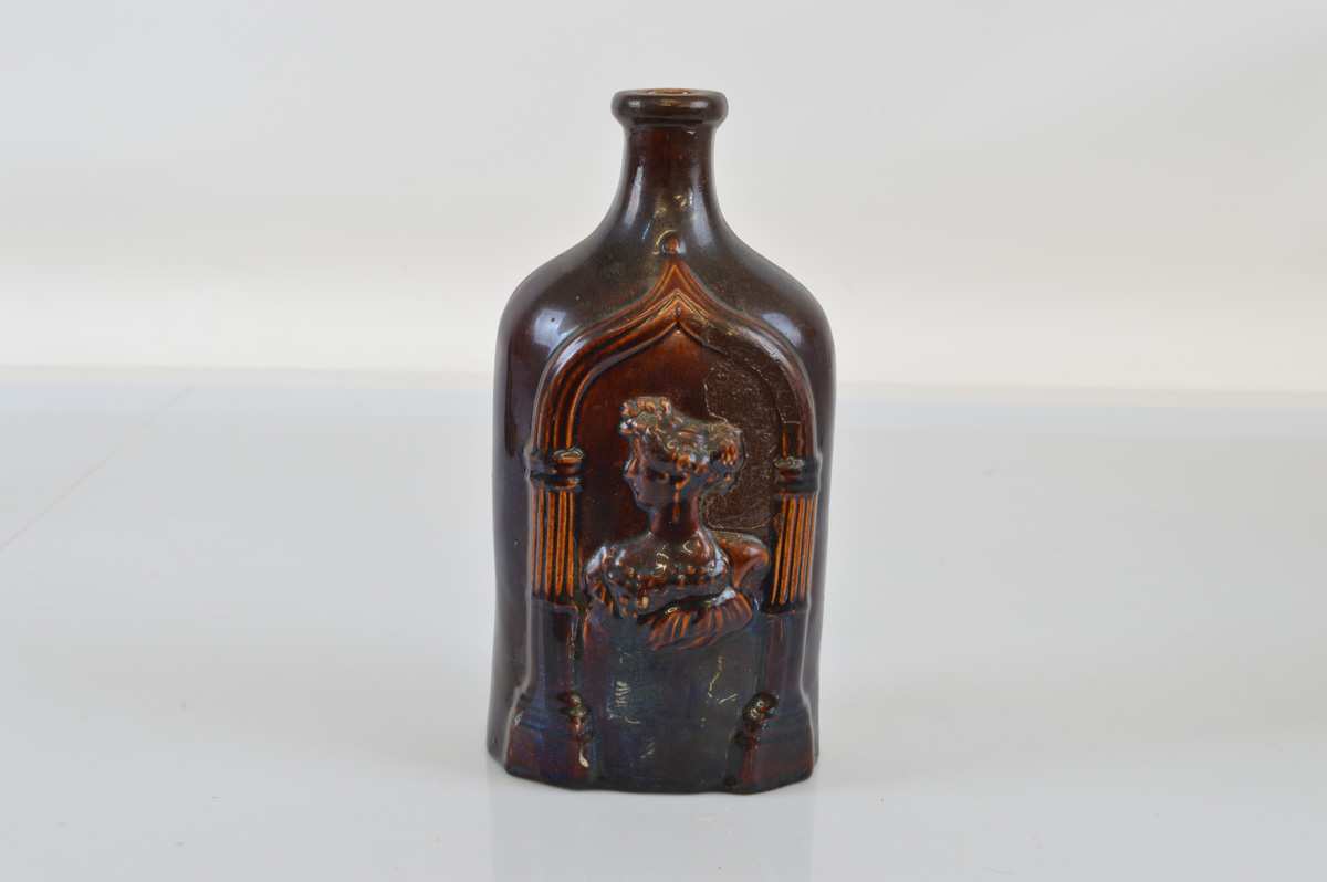 A Victorian treacle glazed flask, having relief female profiles to either side, 23cm high