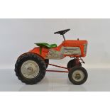 A Tri-ang T M2010 four wheel 'Harvester' Pedal Tractor in orange red, with blown plastic body and