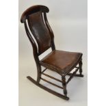 An oak framed rocking chair, having leather and stud upholstered seat and shaped back, spindle front